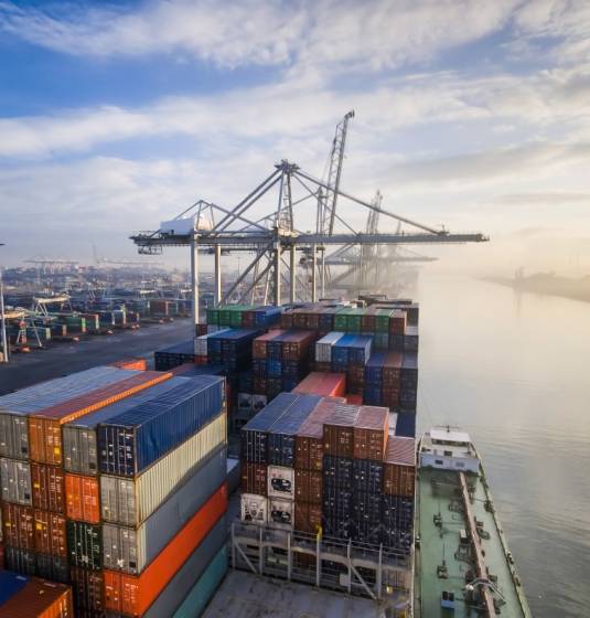 Container operation in port. Sunrise in busy container terminal in Rotterdam, Netherlands.